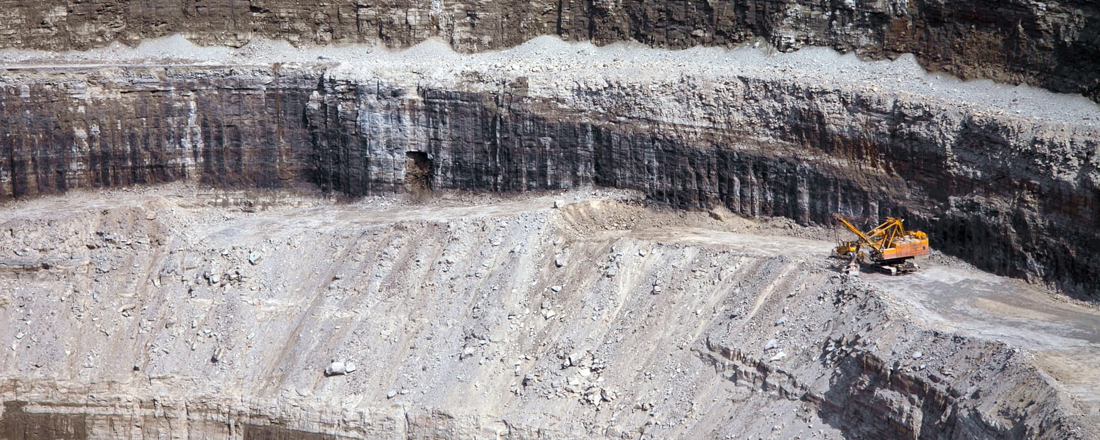 Wall of diamond mine with machinery in the foreground