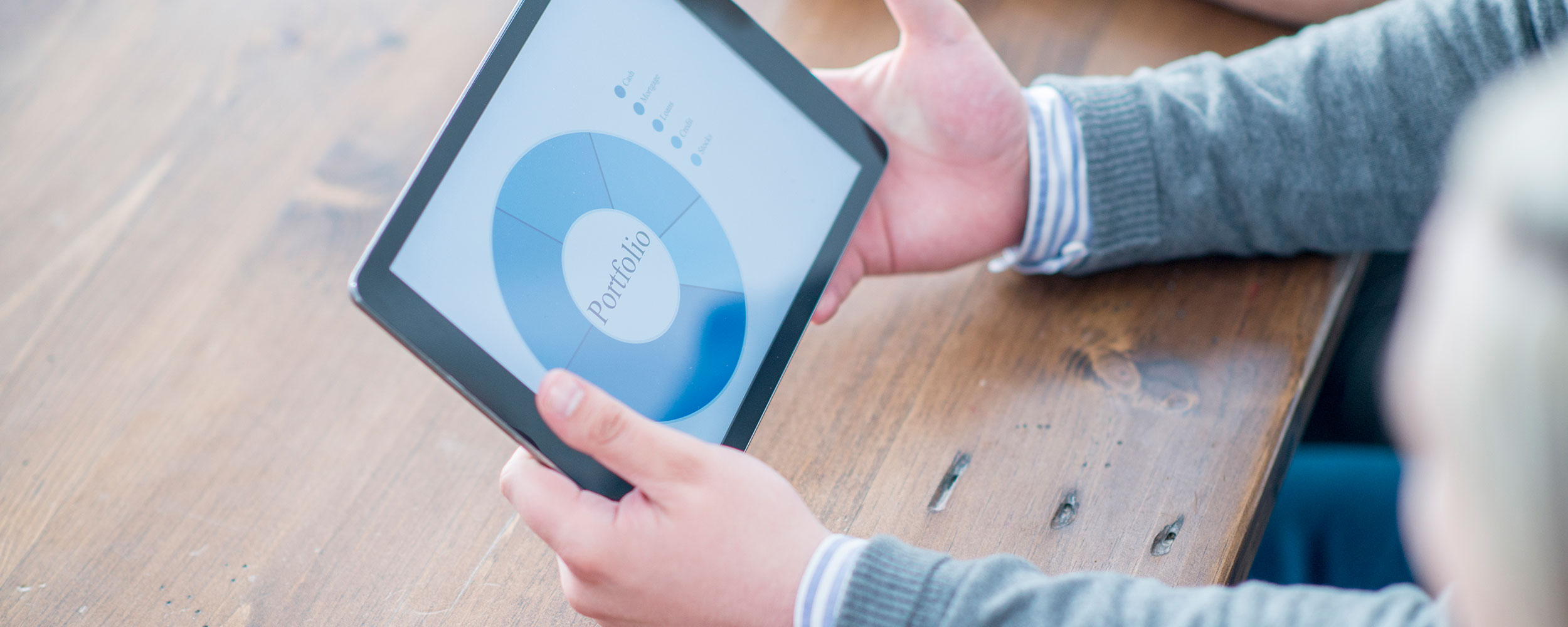 A businessman is looking at a chart of the companies portfolio on a digital tablet.